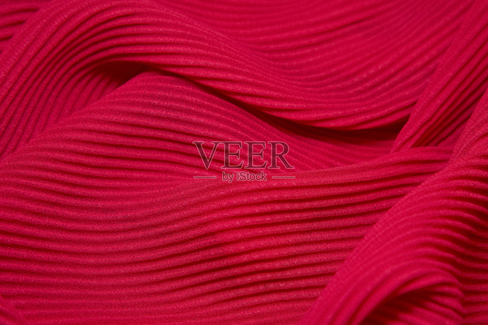 粉色面料背景。粉红色的布波浪背景纹理。粉红色织物织物纺织材料。照片摄影图片