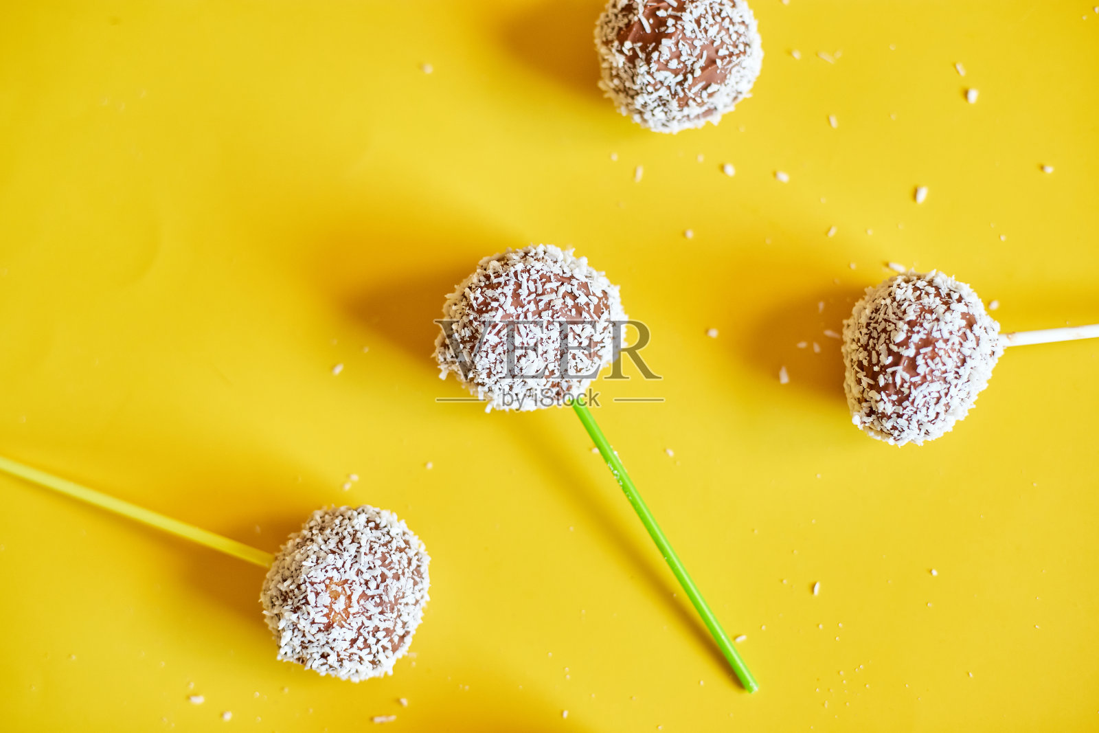 平铺美味的自制椰子和黑巧克力棒棒蛋糕，黄色背景，节日甜点，美味的食物照片摄影图片