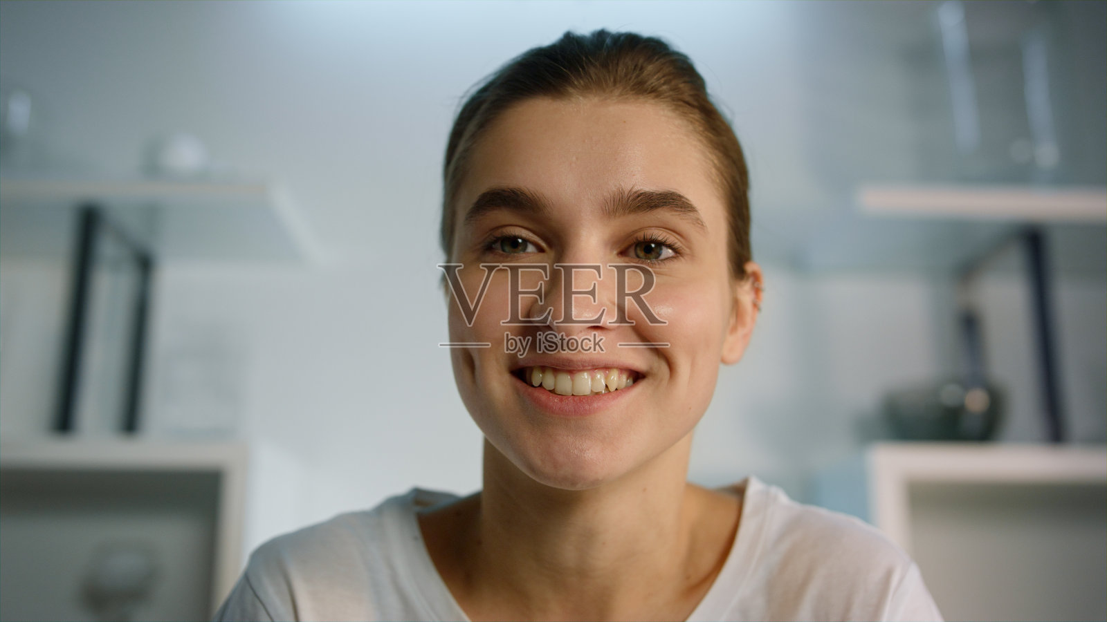 微笑的女孩在家里录制博客特写。漂亮的金发女人挥手照片摄影图片