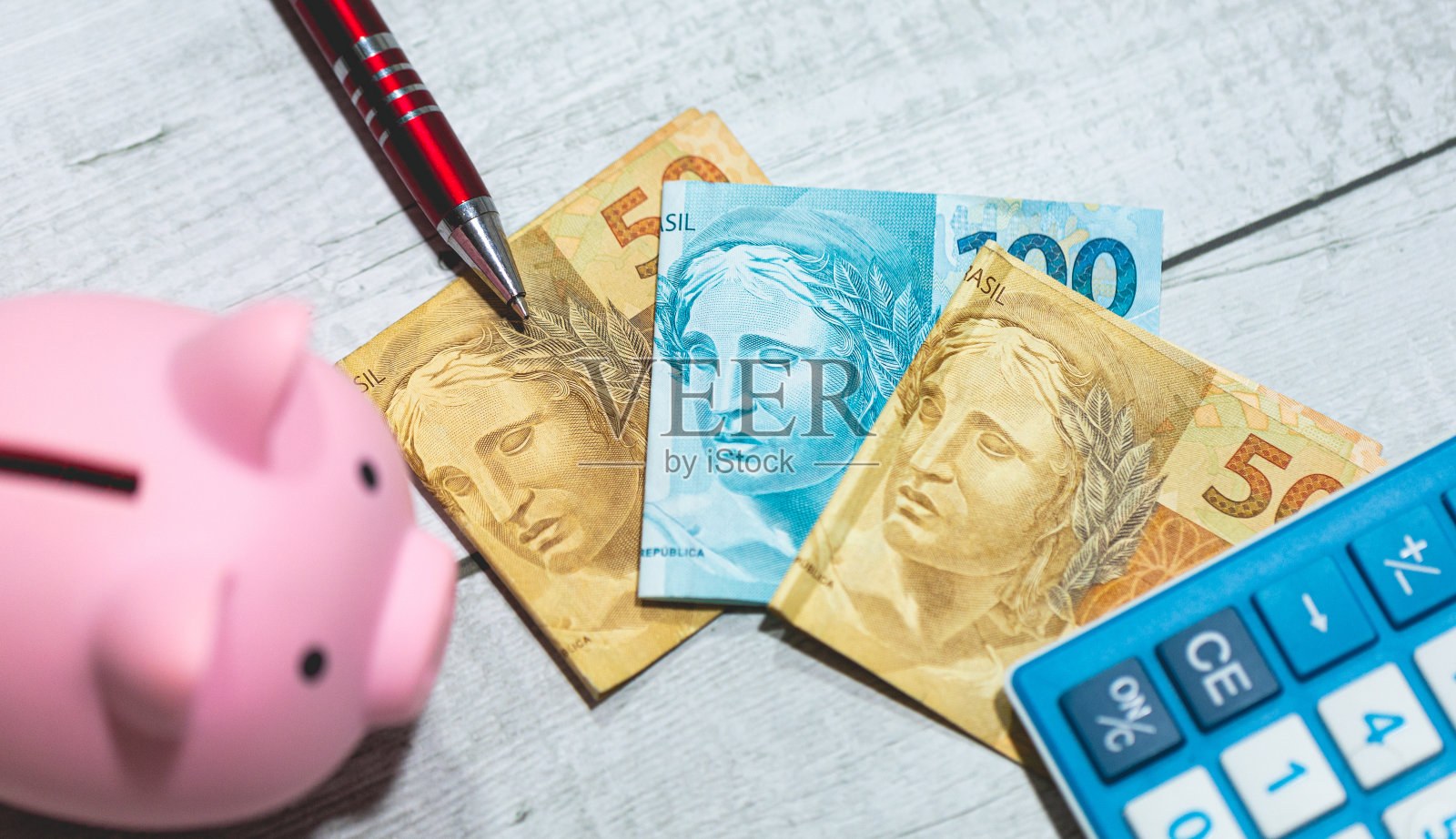 一张木桌上放着巴西雷亚尔钞票和一个存钱罐。巴西经济和投资。照片摄影图片