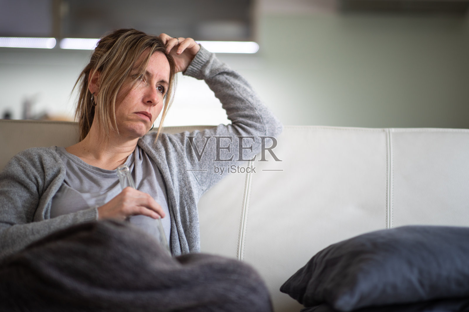 在家中拿着烈酒瓶的中年妇女照片摄影图片