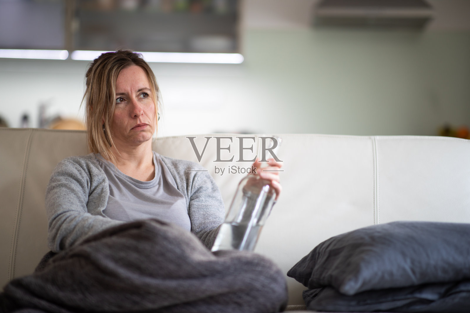 在家中拿着烈酒瓶的中年妇女照片摄影图片