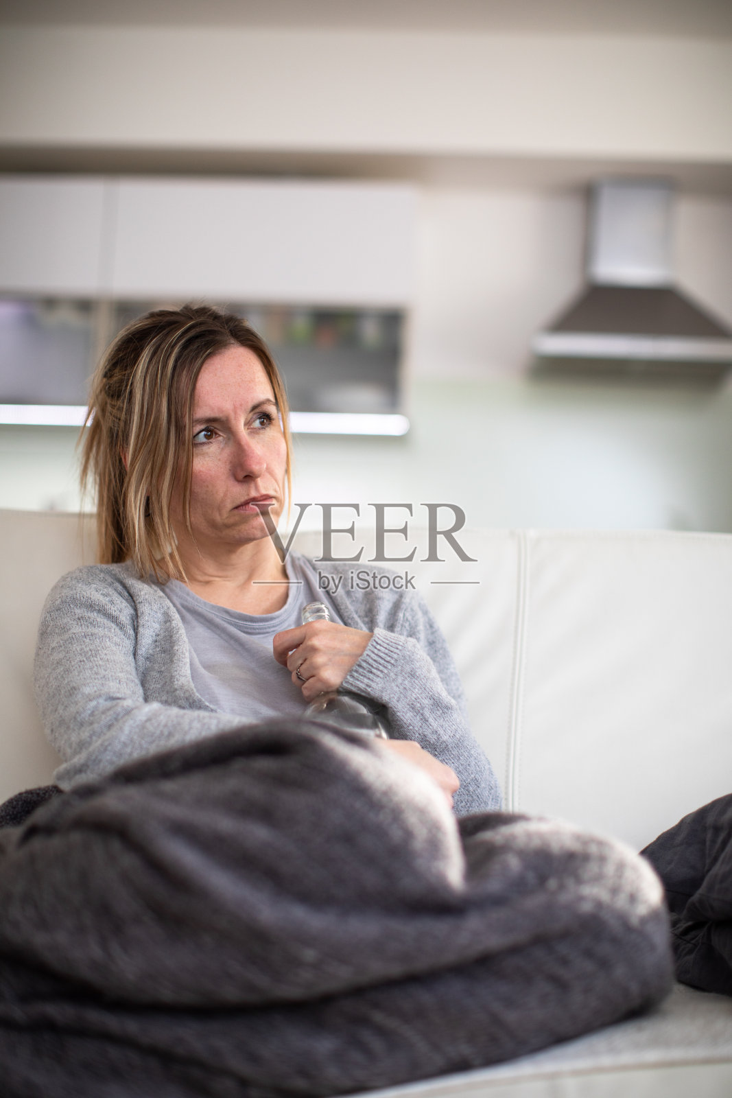 中年妇女在家里喝了一瓶烈性酒照片摄影图片