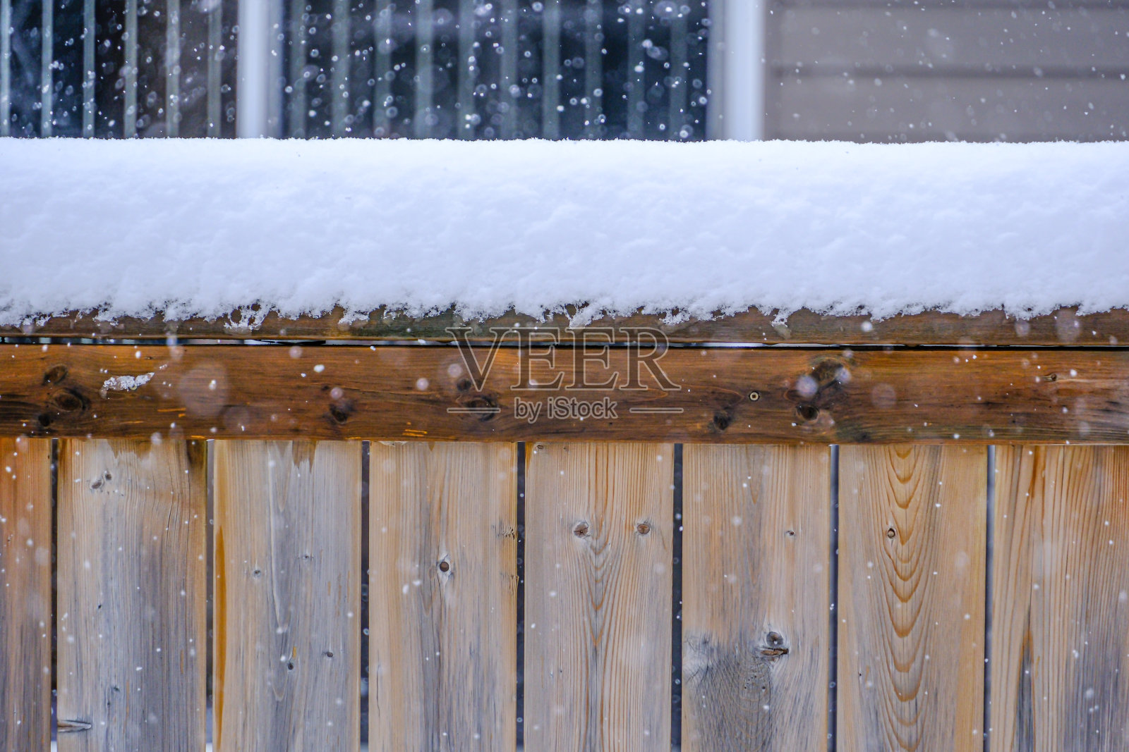 冬天暴风雪时，后院篱笆上的雪照片摄影图片