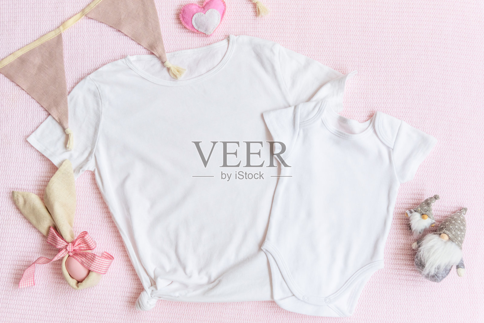 复活节妈妈和孩子们的模型白色t恤和婴儿紧身衣与兔子和复活节彩蛋在粉红色的背景照片摄影图片