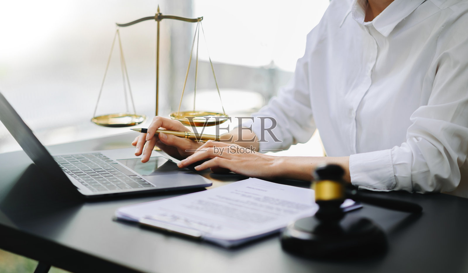 正义与法律观念。男法官在法庭上敲着木槌，工作时用智能手机和笔记本电脑，桌上放着平板电脑照片摄影图片