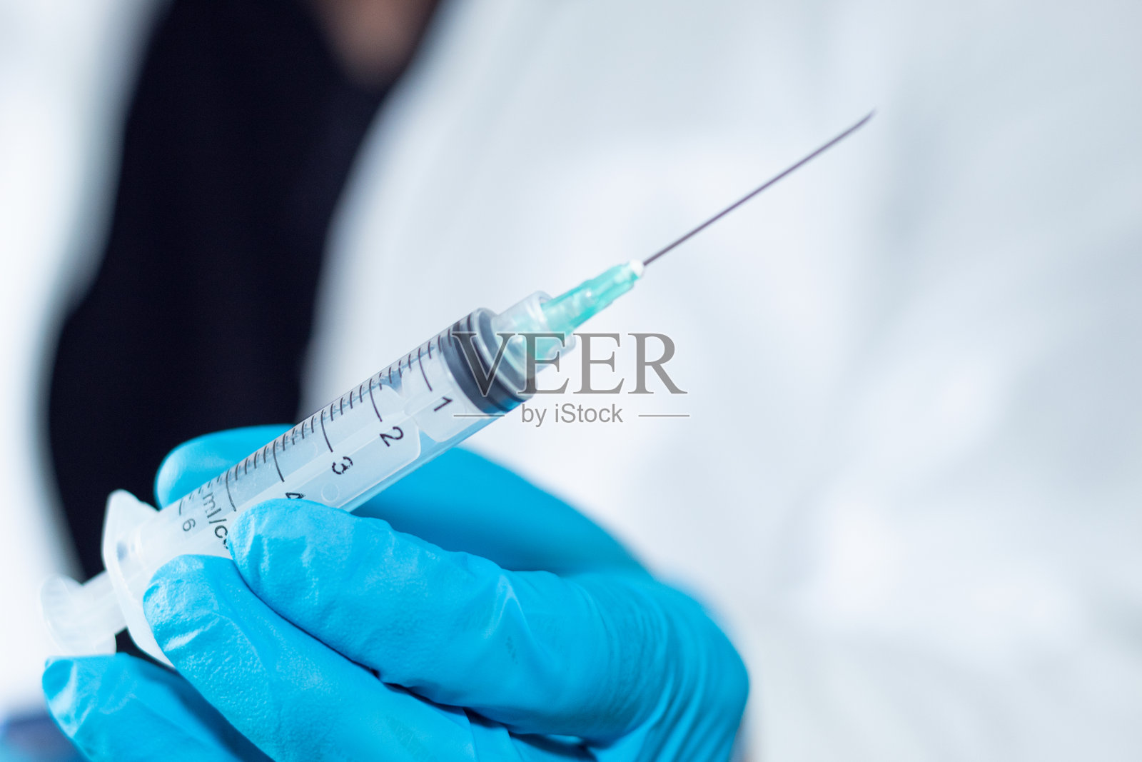 不知名的医生拿着空注射器和针头照片摄影图片