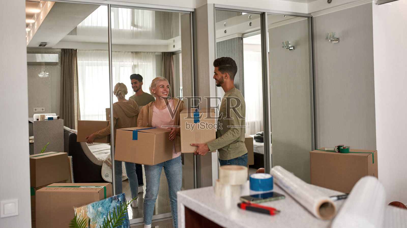 年轻的微笑夫妇在新公寓搬箱子照片摄影图片