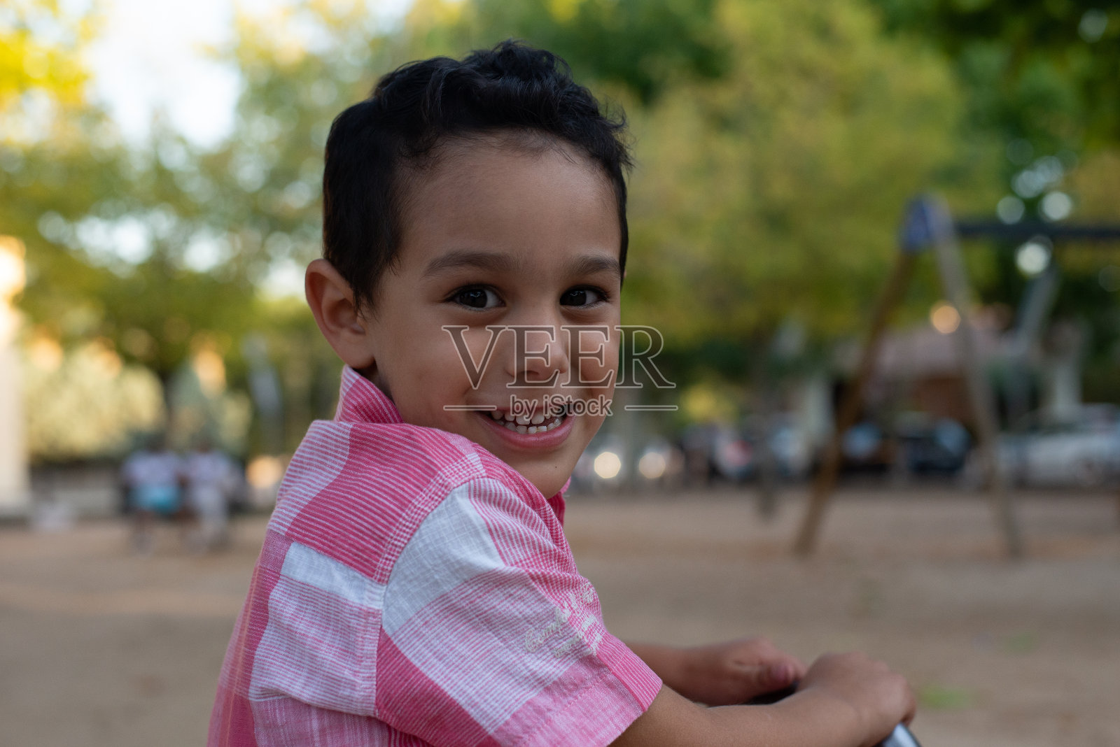 孩子在操场上玩耍跳跃，粉红色衬衫和牛仔短裤，户外游戏，尊重孩子。照片摄影图片