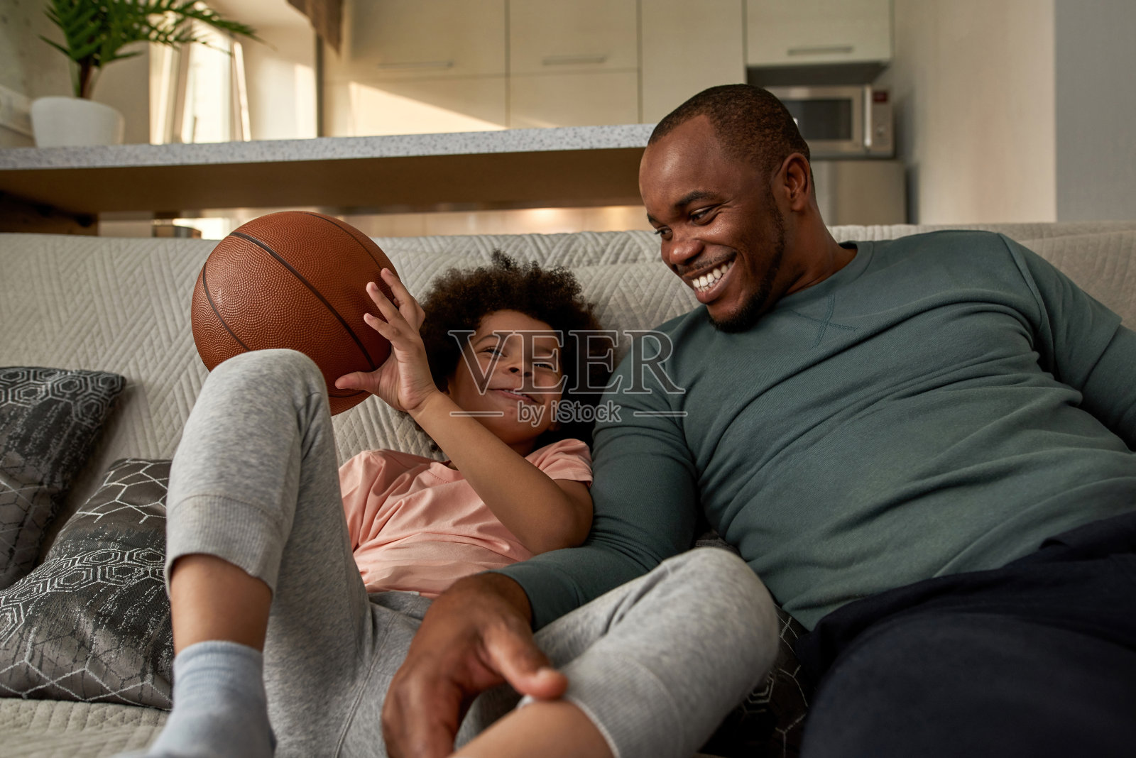 爸爸看着儿子在看篮球转播照片摄影图片