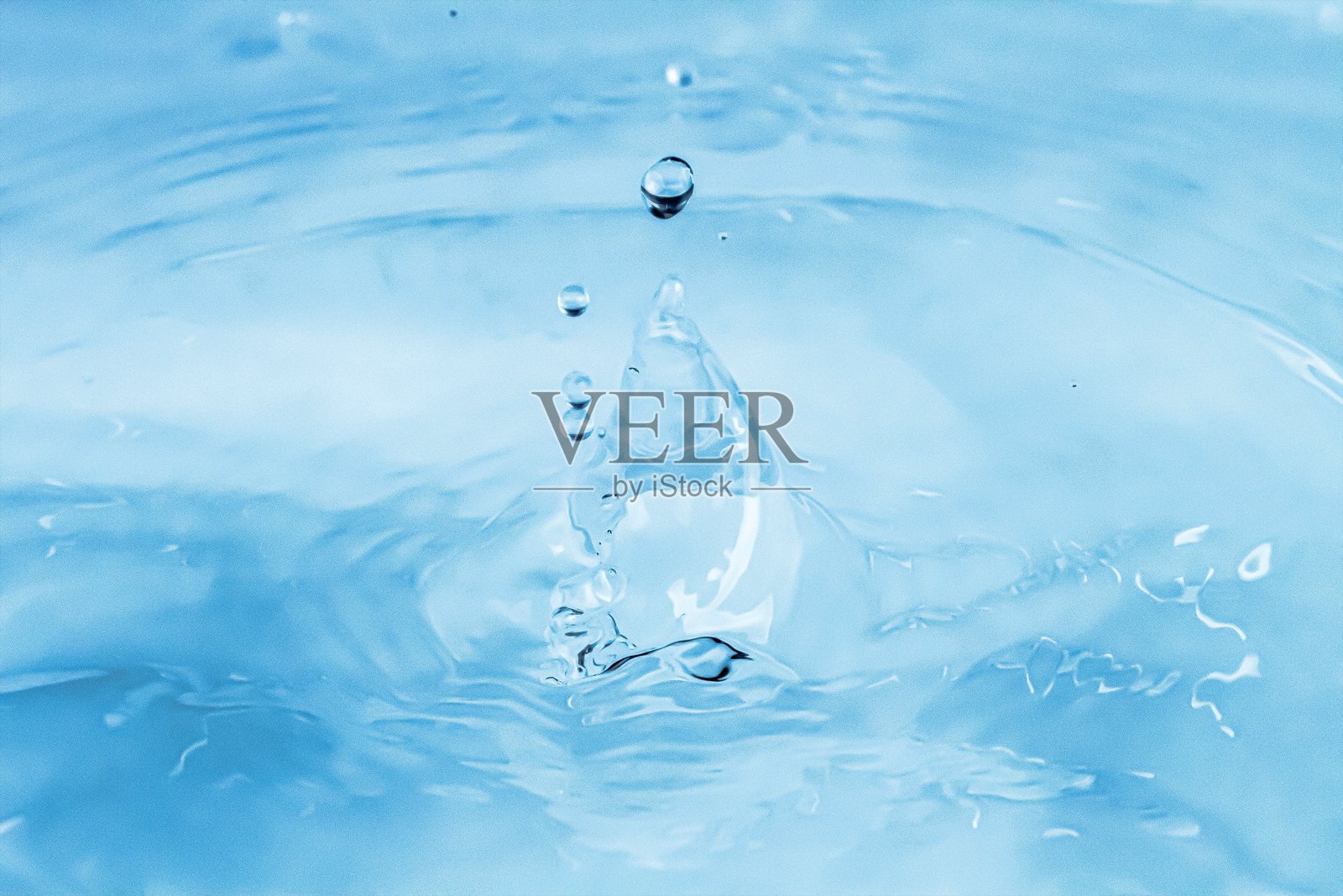 水滴落在水面上，形成一个水冠。照片摄影图片