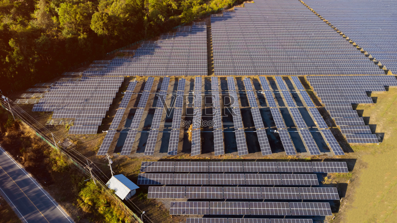 日出日落时的光伏太阳能电池板。太阳能电池板电池在戏剧性的日落天空背景，清洁替代能源的概念。照片摄影图片