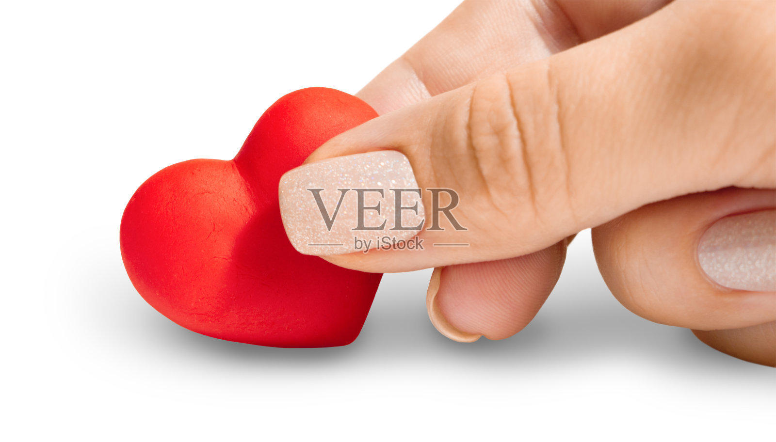 女人的手牵着一颗孤立的心就白了照片摄影图片