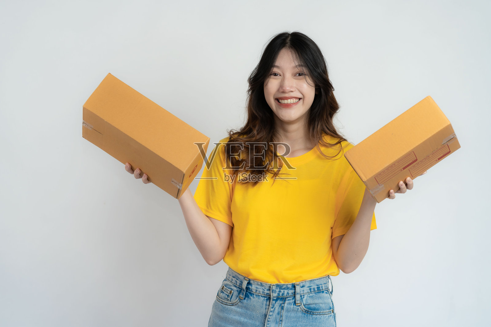 年轻的亚洲女子拿着一个盒子，带着迷人的微笑，孤立在白色的背景上。网上中小企业业务及配送理念。照片摄影图片