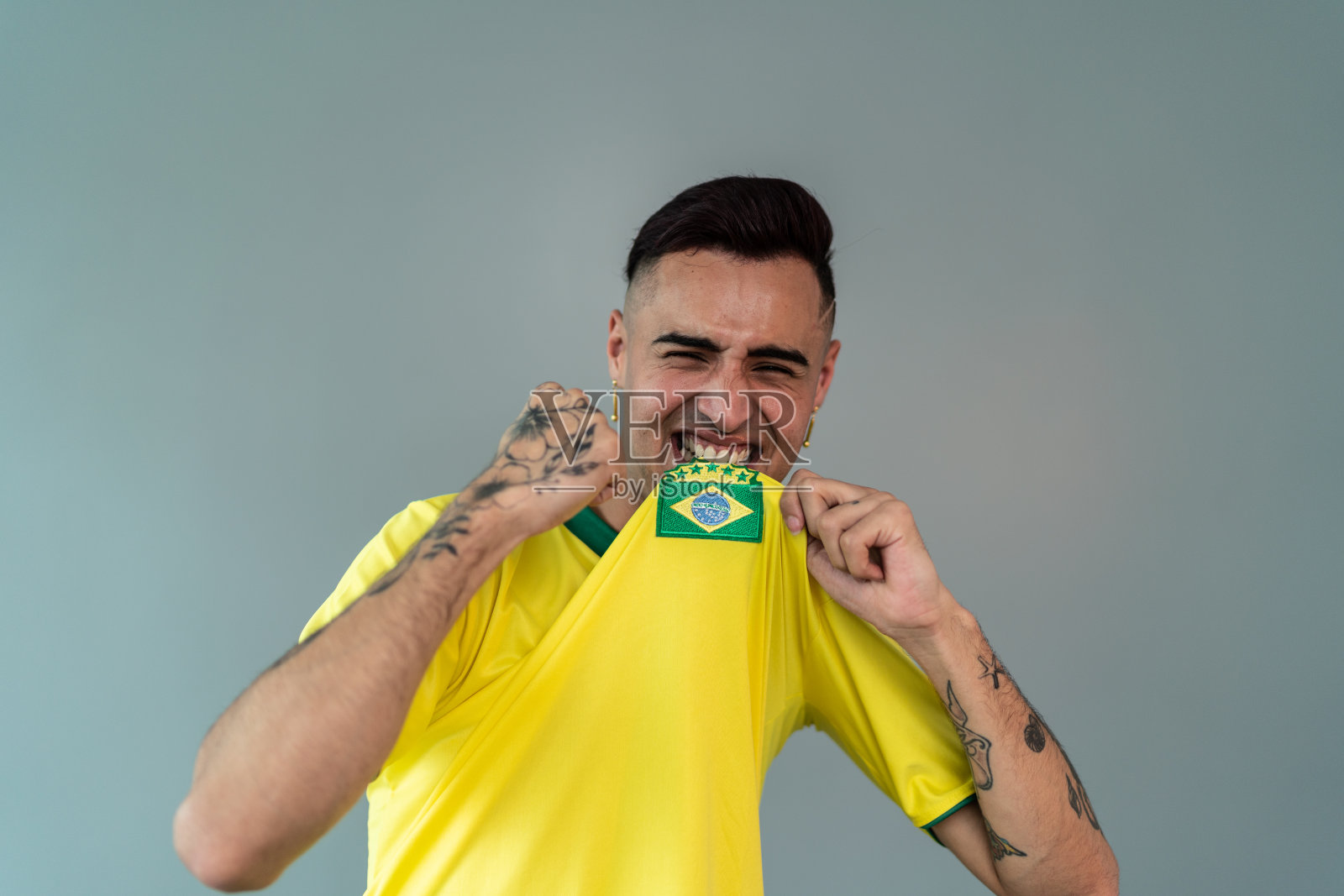 一个年轻人庆祝巴西队获胜的肖像在一个工作室拍摄照片摄影图片