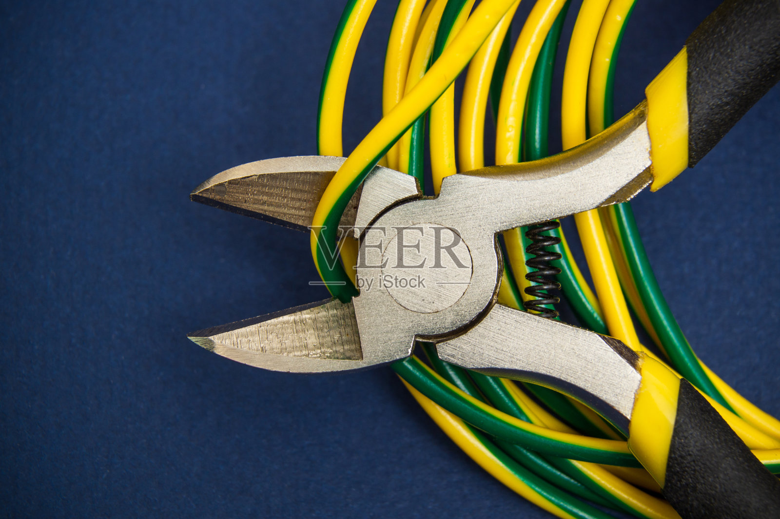 断线钳或斜口钳和电线关闭在深蓝色的背景照片摄影图片