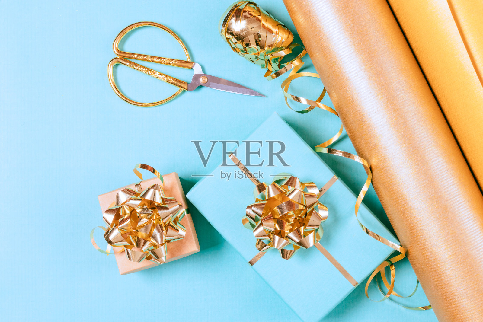 蓝色背景上的金色丝带和剪刀照片摄影图片