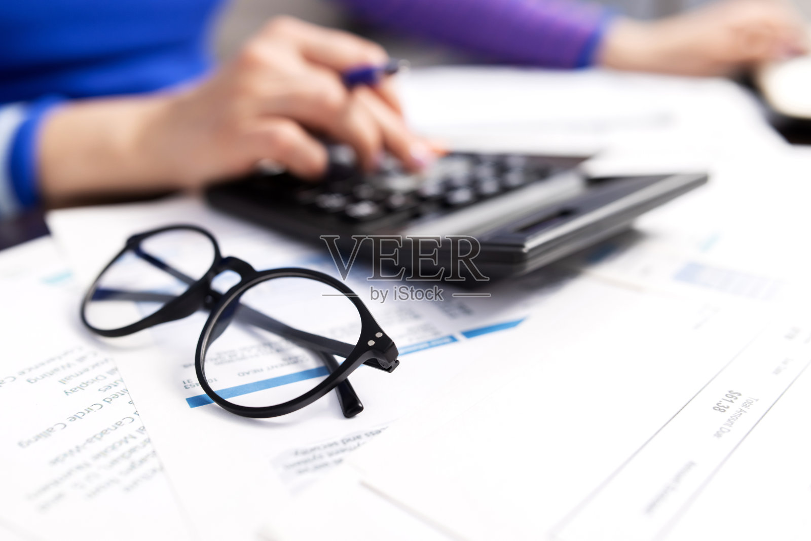 女人在家里用计算器计算家庭账单照片摄影图片