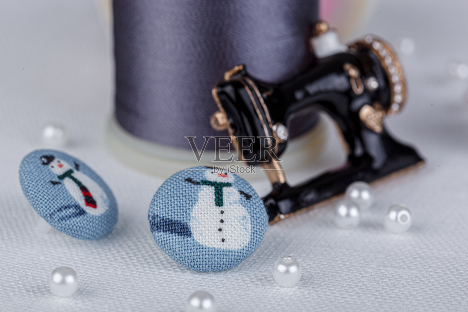 静物的一缕线用于缝纫，针，纽扣，缝纫机在一个白色的背景照片摄影图片