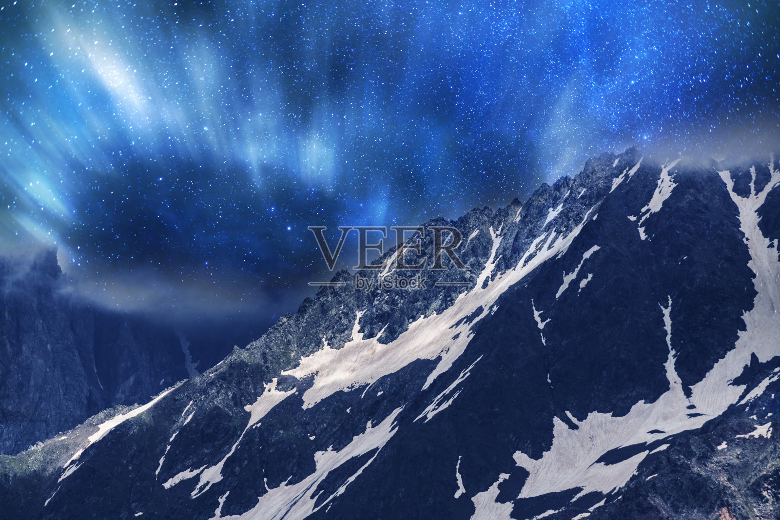 梦幻般的夜景。美丽的雪山在星夜与银河。照片摄影图片