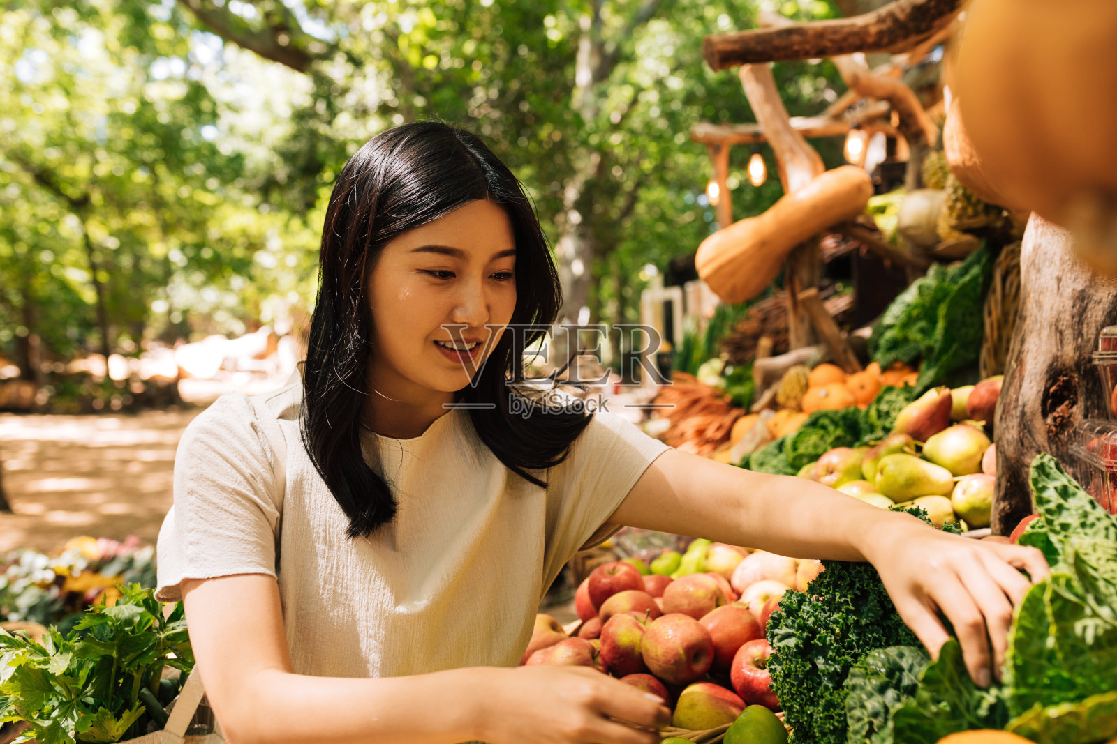 年轻女子在户外市场挑选生菜照片摄影图片