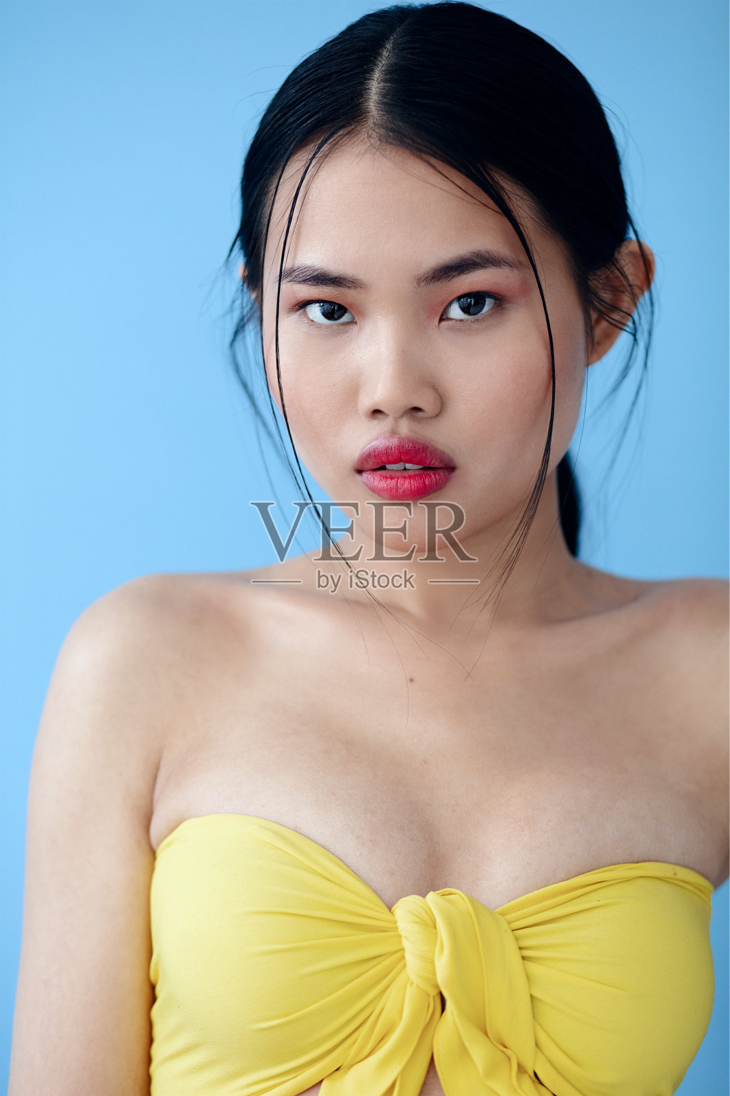 美丽的亚洲女人在工作室的蓝色背景。照片摄影图片