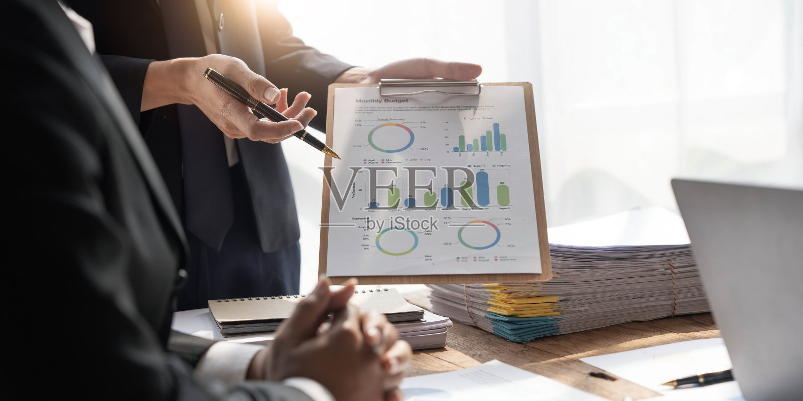 商务人士会议使用笔记本电脑，计算器，笔记本电脑，股票市场图表分析纸计划下个月提高质量。会议讨论企业概念照片摄影图片