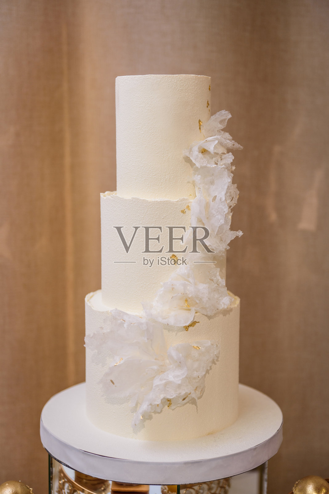 婚宴上用白色花朵装饰的结婚蛋糕。美味的接待。副本的空间。庆祝派对概念。金色装饰的时尚蛋糕。关闭了。照片摄影图片