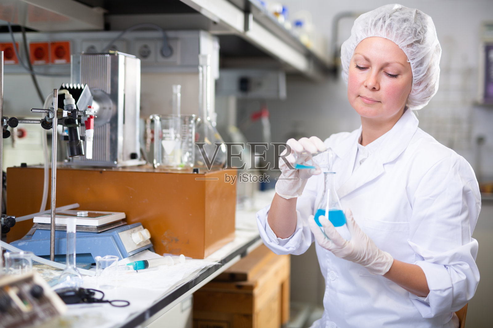 在实验室工作的女性化学家，分析测试瓶中的液体样品照片摄影图片