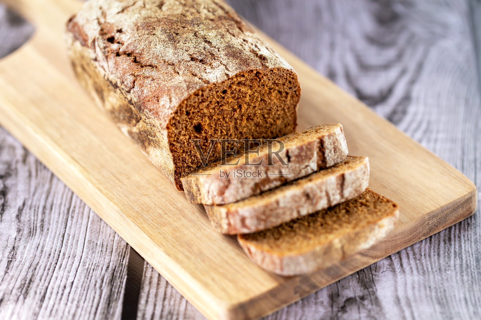 一块面包放在切好的木板上照片摄影图片