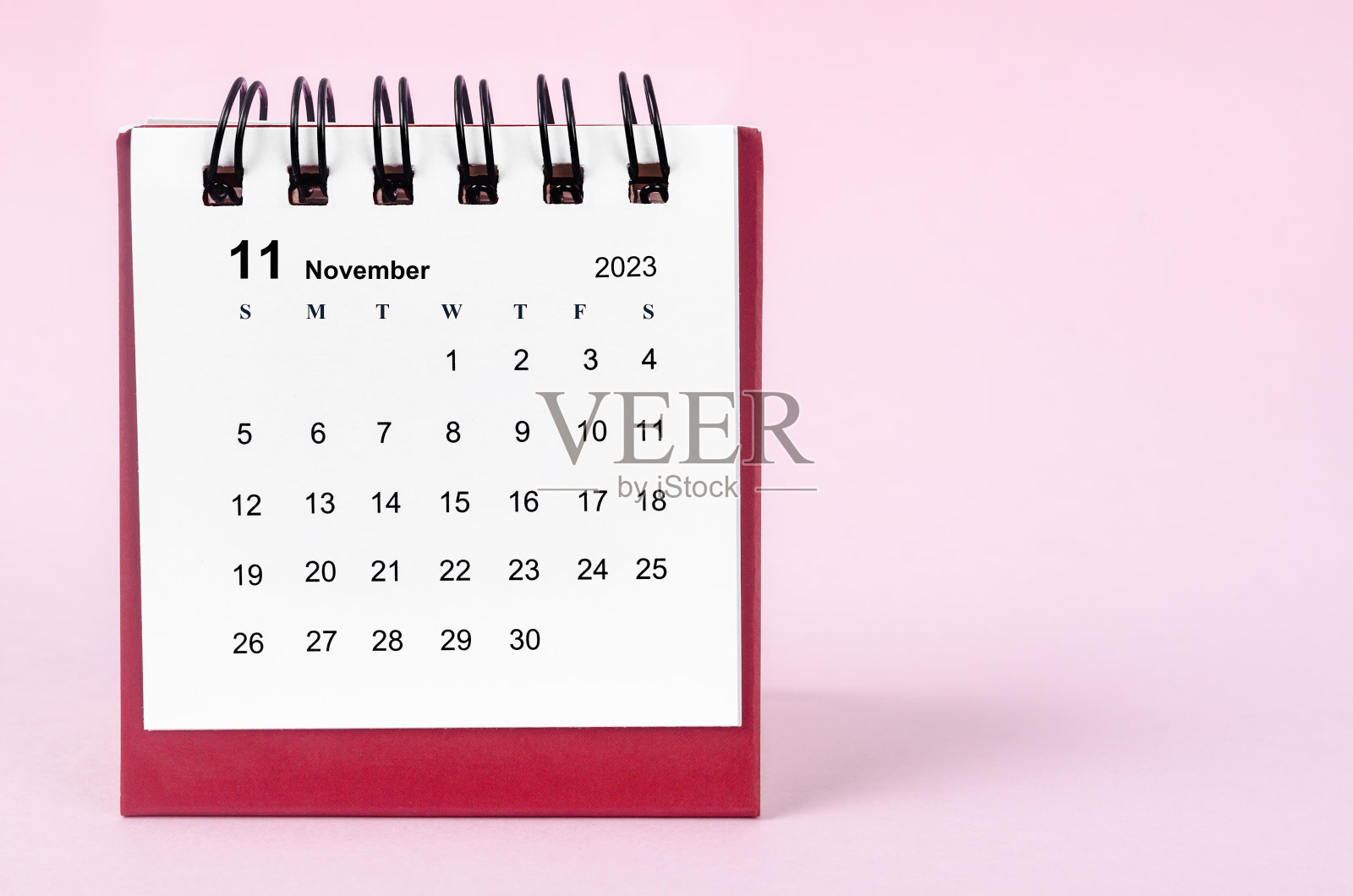 2023年11月的台历，粉红色背景。照片摄影图片