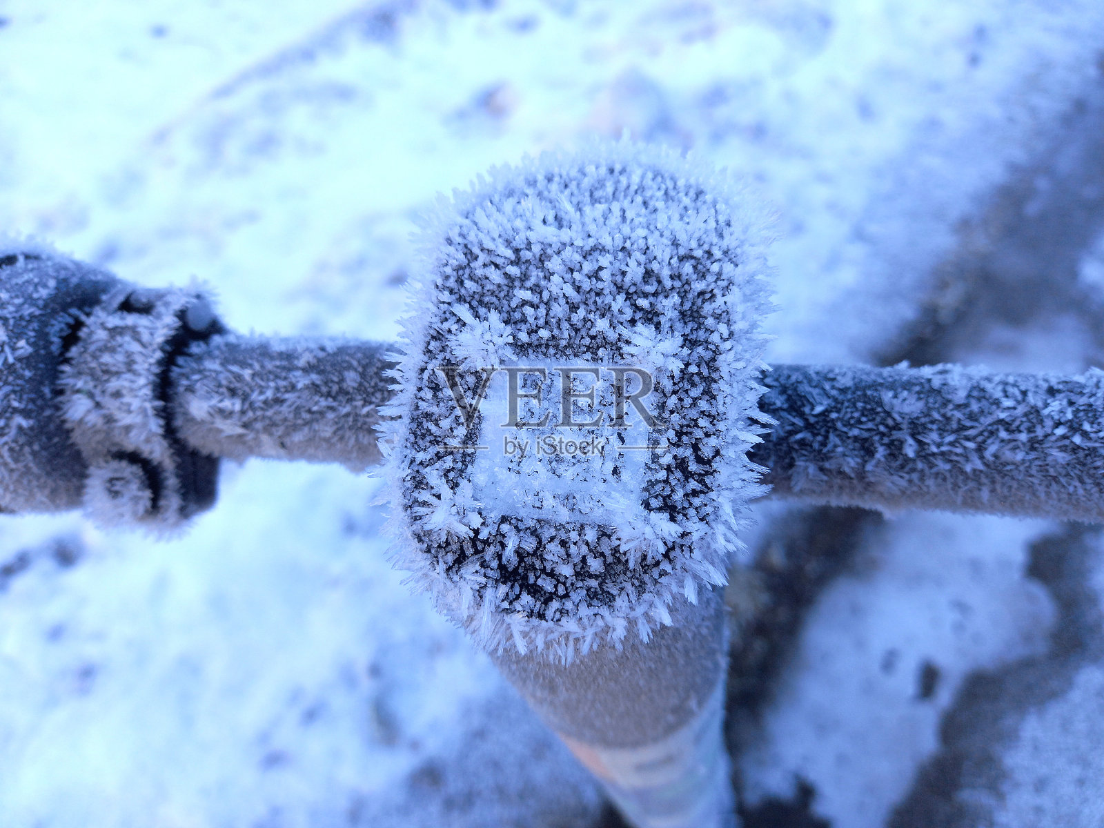 覆盖着冰晶的寒冷天气，电动滑板车二维码验证照片摄影图片