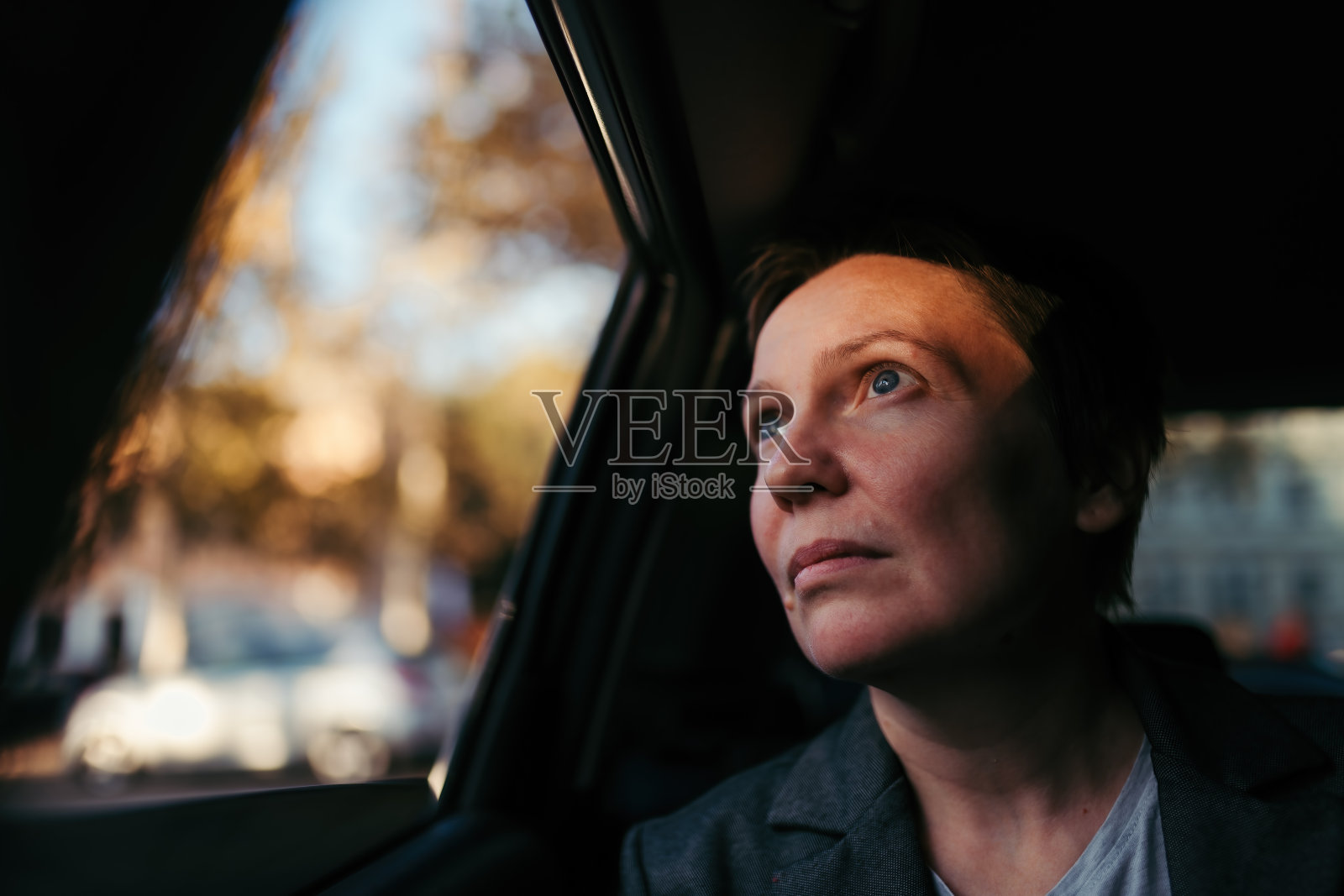 满怀希望的女商人看着车窗外的天空照片摄影图片