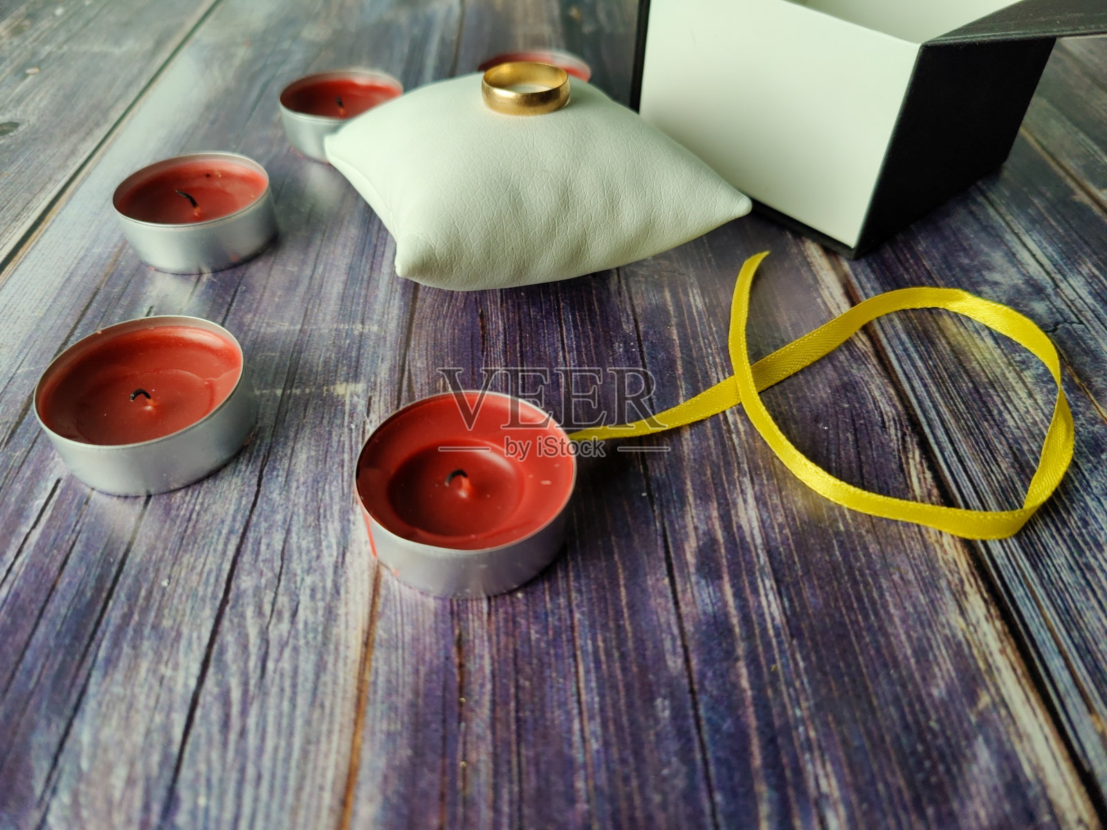 红蜡烛，金戒指和情人节的礼盒照片摄影图片