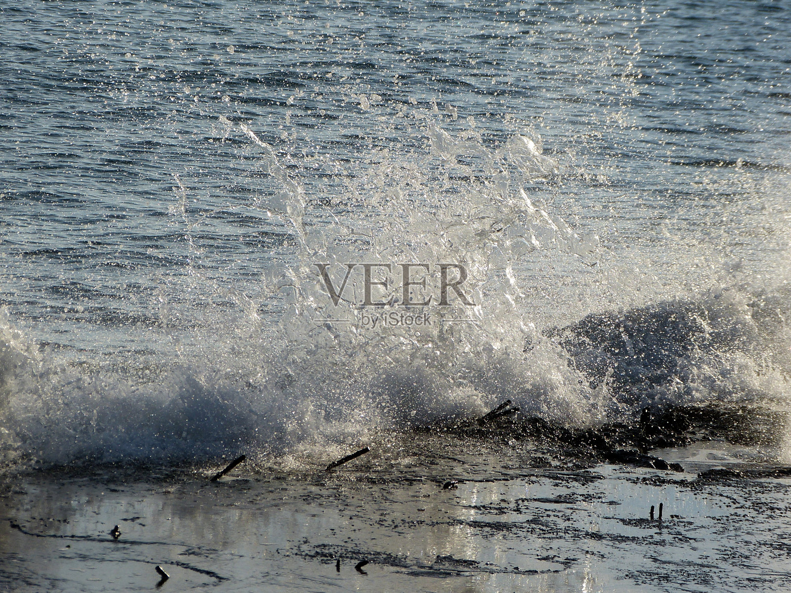 飞溅的海浪拍打着海岸照片摄影图片