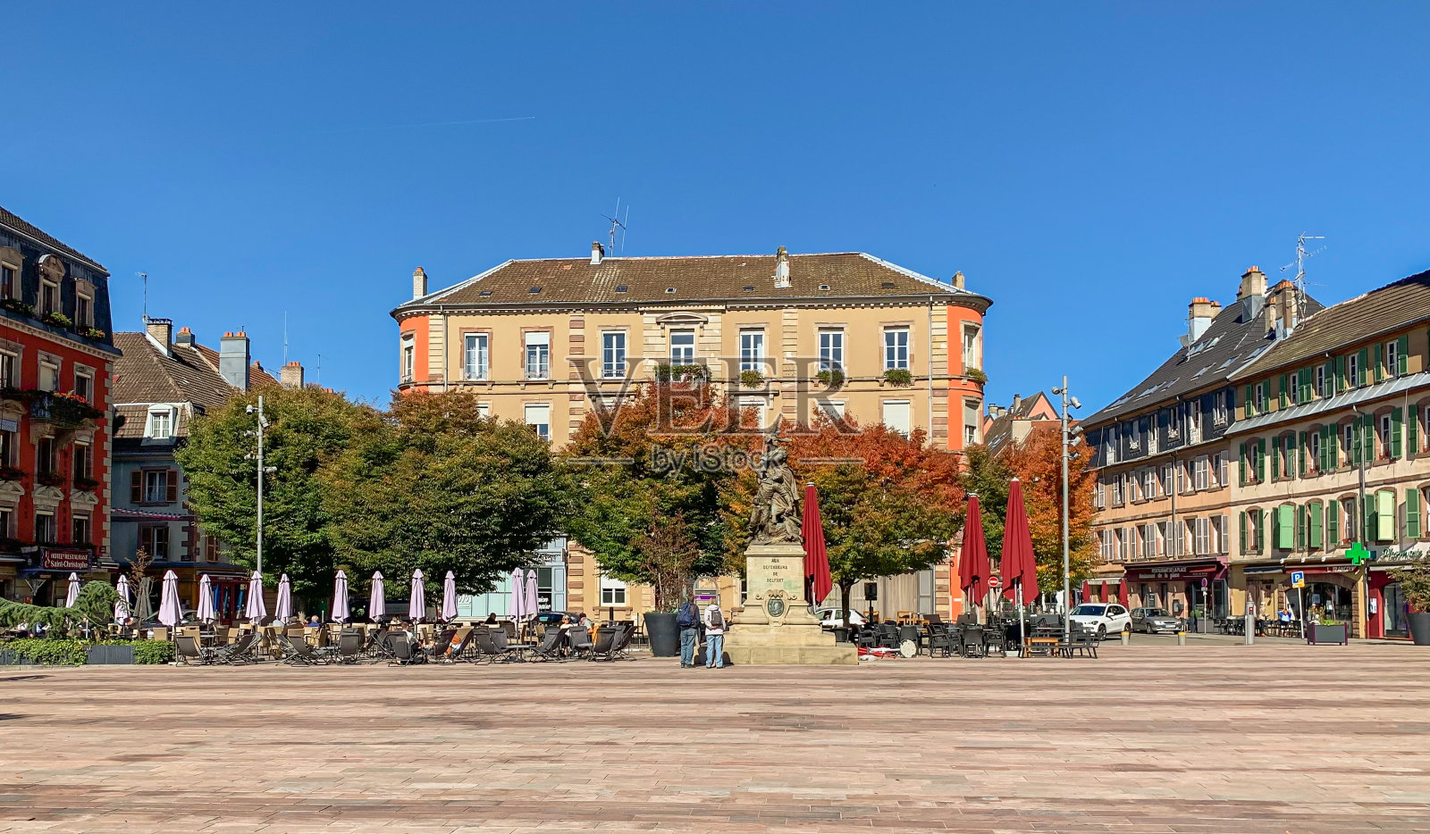 法国贝尔福——2022年9月:手臂广场——贝尔福市的主要广场:英雄纪念碑、整齐的树木、咖啡馆和餐馆、市政建筑照片摄影图片