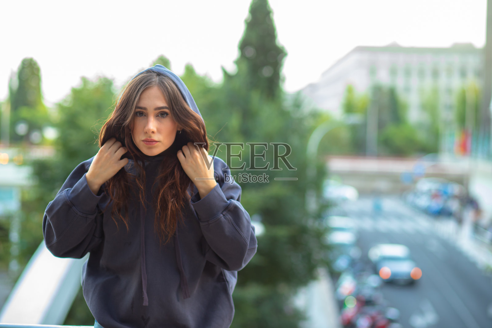 穿着帽衫的严肃女人站在桥上照片摄影图片