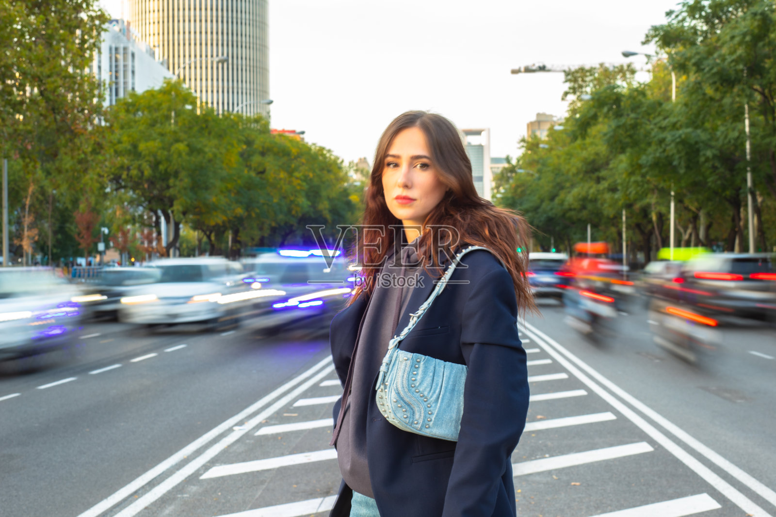 时髦的女人站在交通岛上照片摄影图片