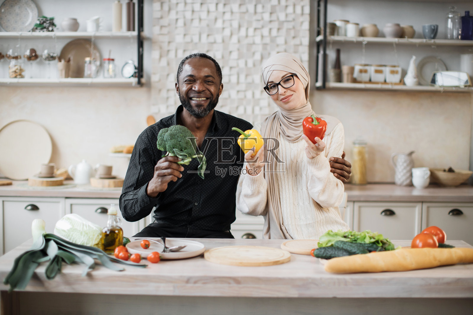 有吸引力的非洲裔美国男子和穆斯林年轻女子一起做饭照片摄影图片