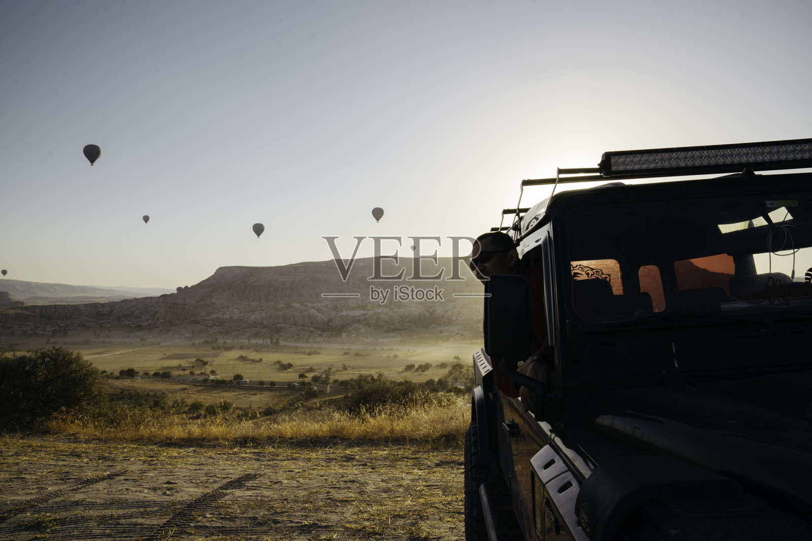 年轻的亚洲男子享受日出与热气球的观点在戈尔梅照片摄影图片