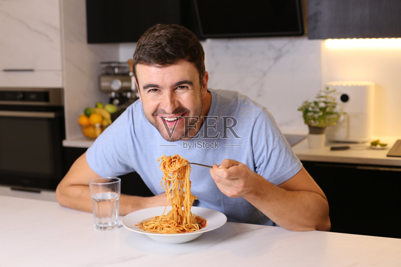 一名男子正在享用一盘意大利面照片摄影图片