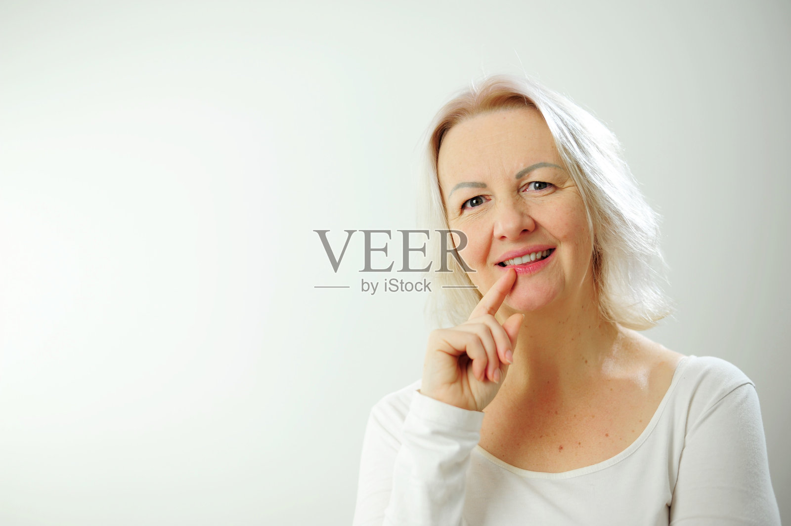 快乐快乐的成人美丽的女孩看着相机微笑着笑在白色背景美丽的偷拍女人短发，不化妆干净的面部皮肤微笑，站在t恤照片摄影图片