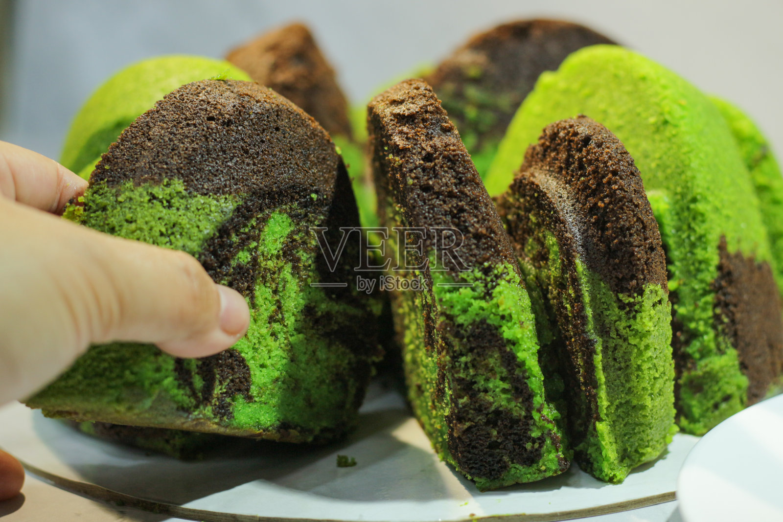 女人手拿大理石蛋糕。玛默蛋糕，杰杜尔。香兰黑糯米奶油蛋糕。古老的传统收据。有选择性的重点。美味。照片摄影图片