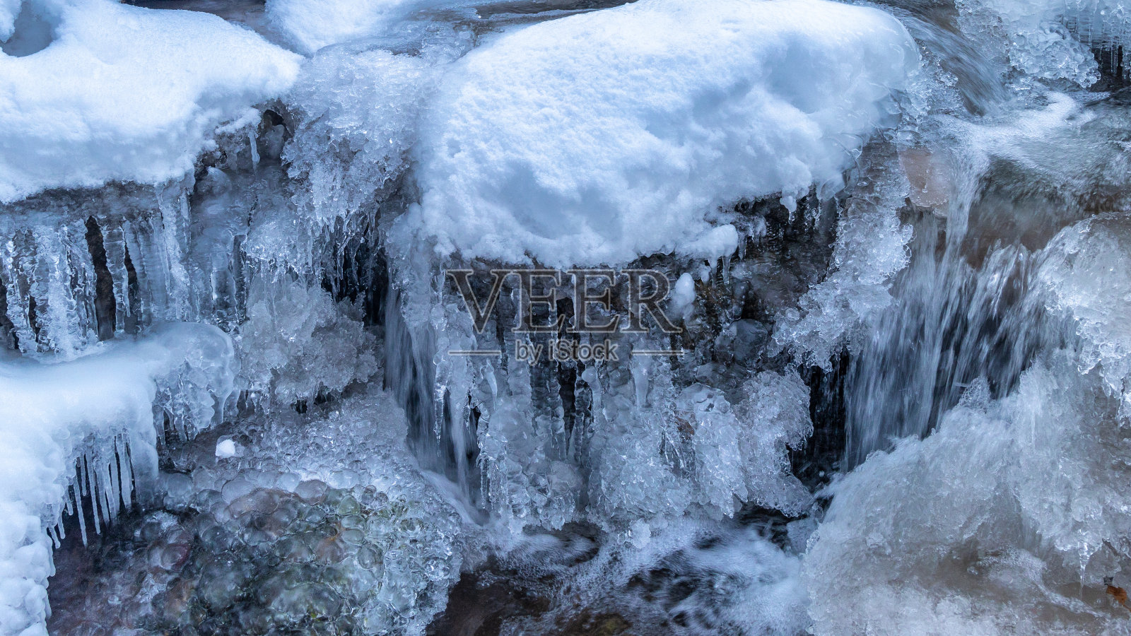 白雪皑皑的冬季景观与野生溪流。照片摄影图片