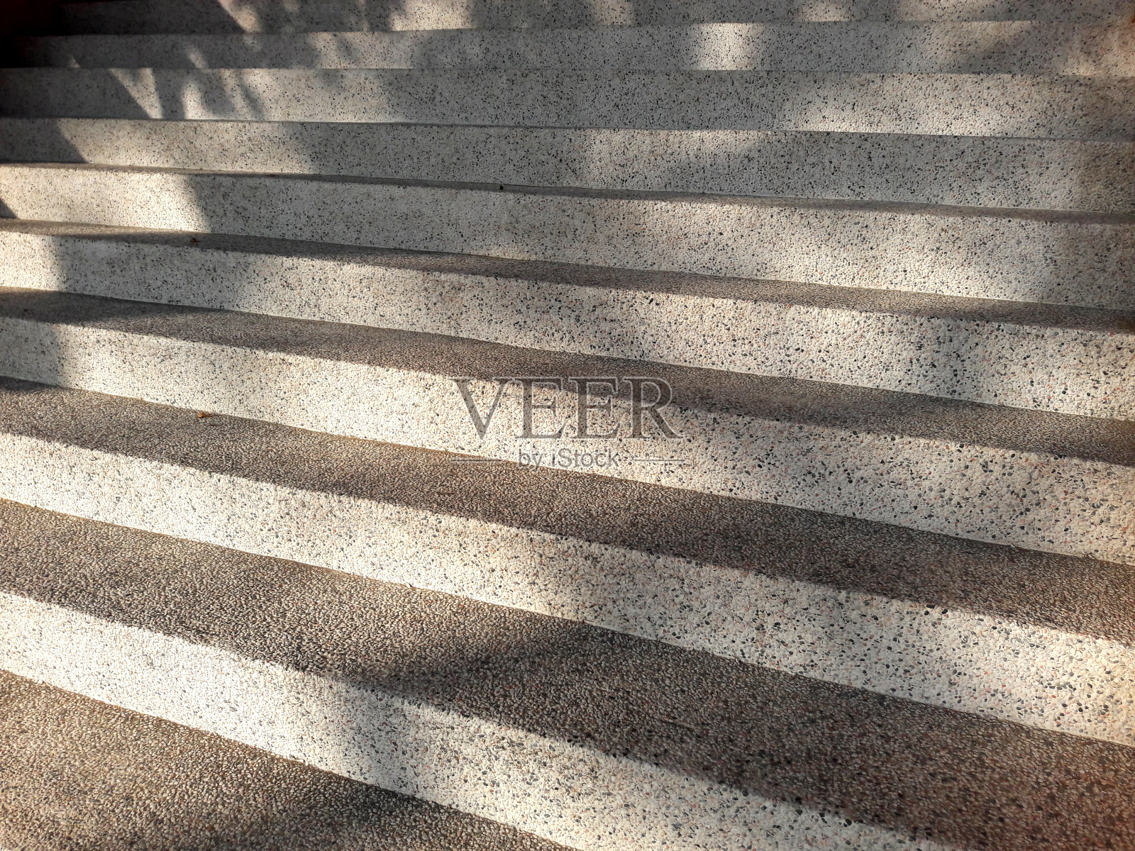 抽象的水泥或混凝土结构的楼梯或台阶。对角线条纹或线条图案为背景。树叶在楼梯上的倒影。照片摄影图片