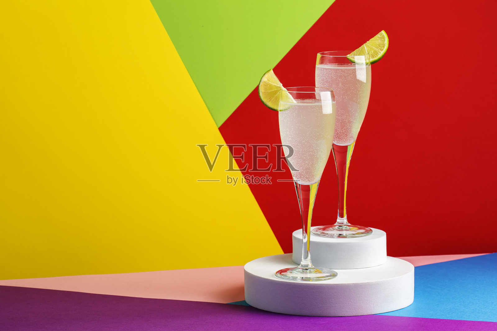 法国75，含干杜松子酒，普罗赛克，糖浆和柠檬汁的酒精鸡尾酒。现代风格的静物在明亮的多色背景照片摄影图片