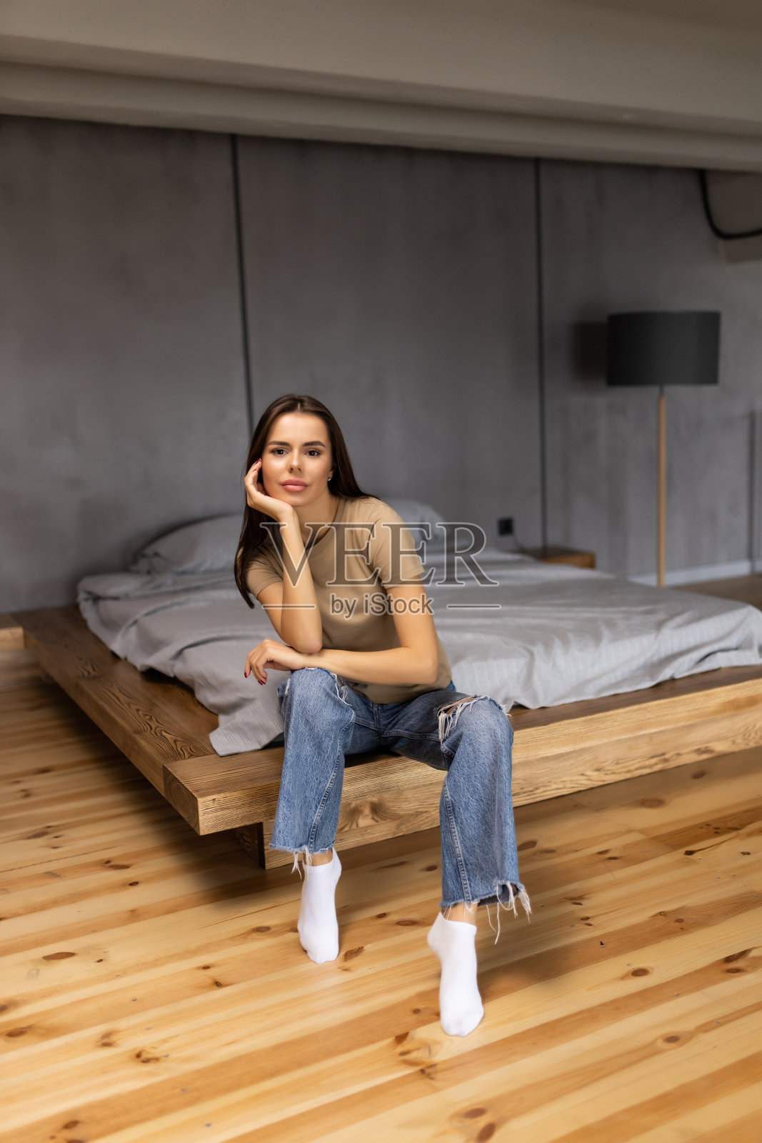 年轻漂亮的女人坐在家里的床上照片摄影图片