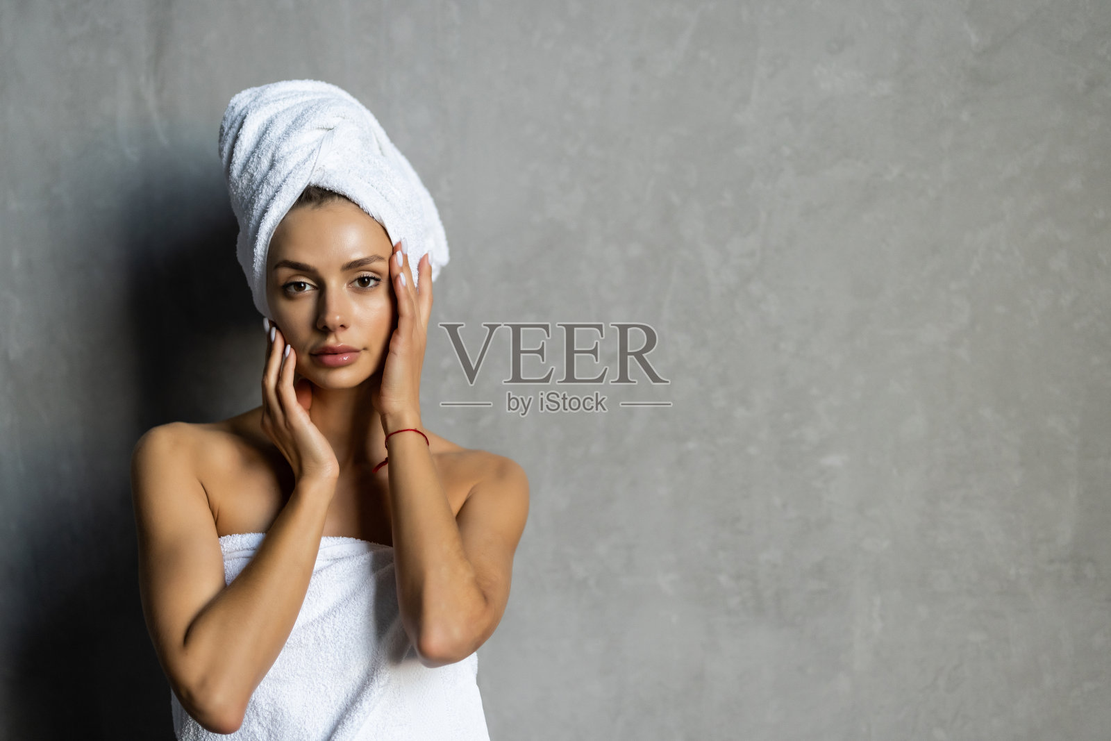 一个年轻健康宁静的女人女孩在浴袍和水疗毛巾放松后在家里洗澡的肖像。美容、休息和身体护理程序。照片摄影图片