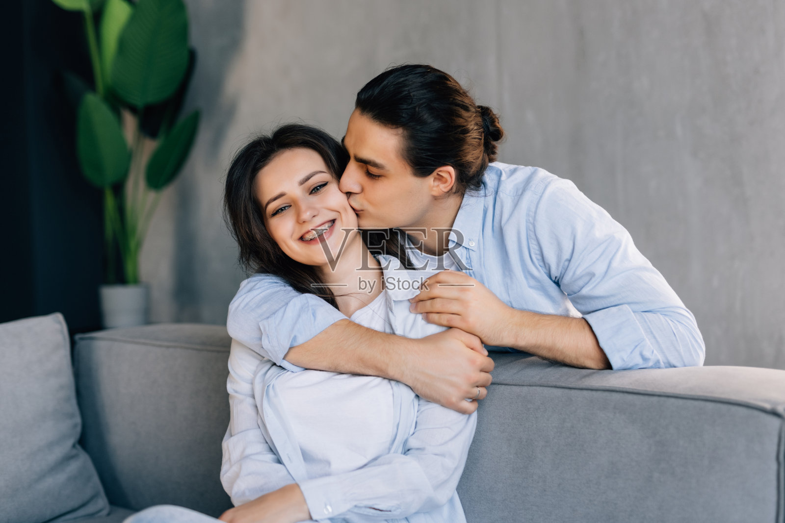 有爱的丈夫安慰心烦被冒犯的妻子，从背后爱抚和拥抱她。照片摄影图片