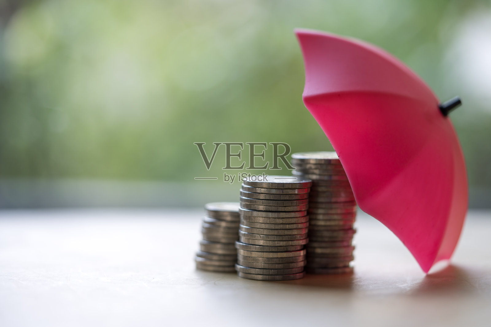 红伞和一堆硬币。保证资金安全。储蓄的保护。照片摄影图片